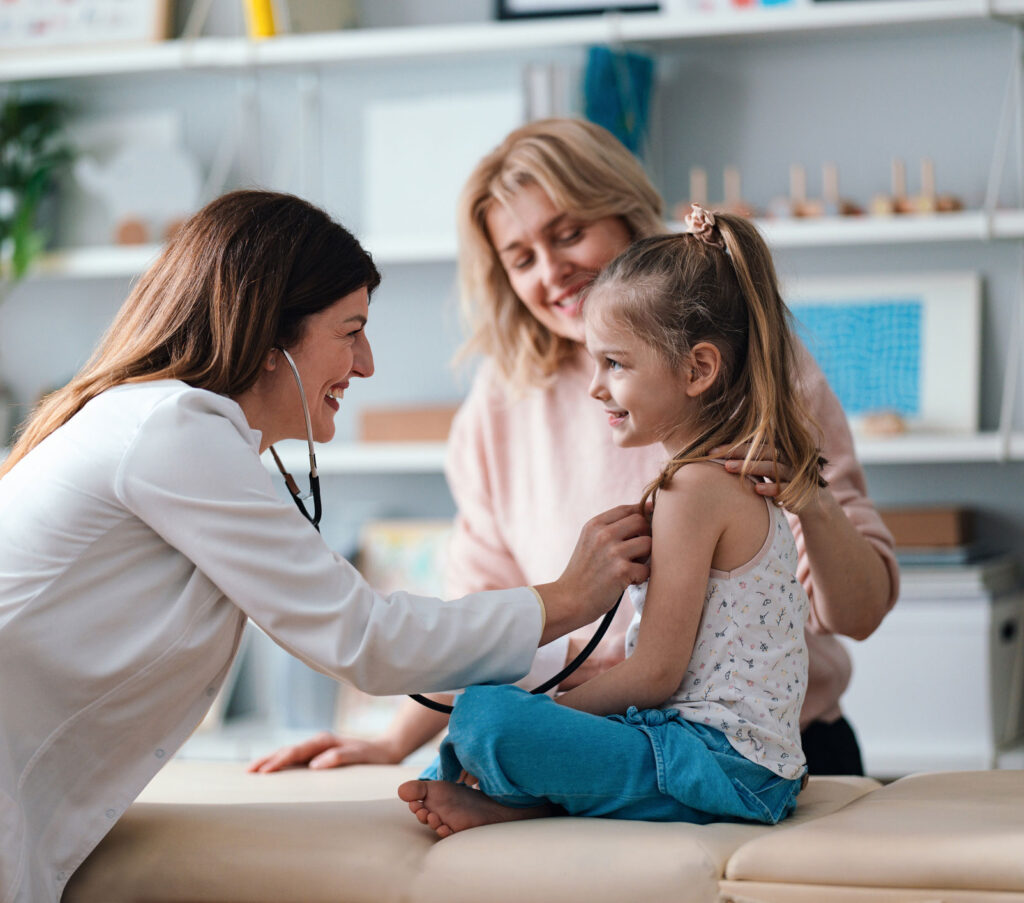 doctor treating young girl with her mom in an exam room