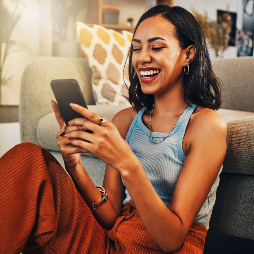 woman on couch with phone in hand